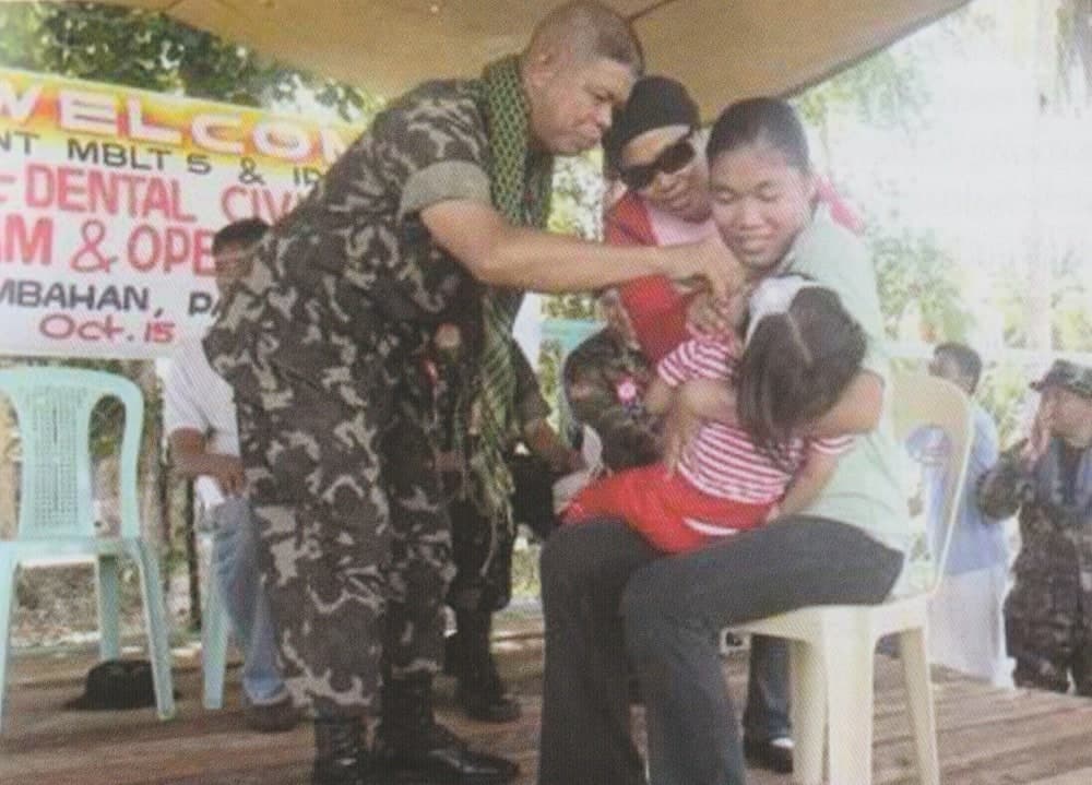 3rd Marine Brigade COL Eugene Clemen PN(M) leads the giving of vitamins